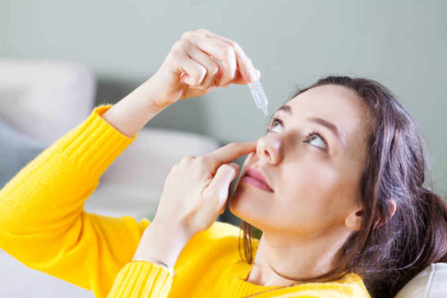 Eye infection treatment using eye drops Eye drops treatment for conjunctivitis eye infection redness relief, Close up image of woman using eye drops for treatment of dry eye, eye infection, allergy and irritation. Eye drops help relieve redness watering burning and discomfort.